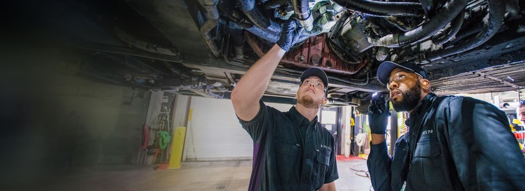Two Delta engineers look up at an engine