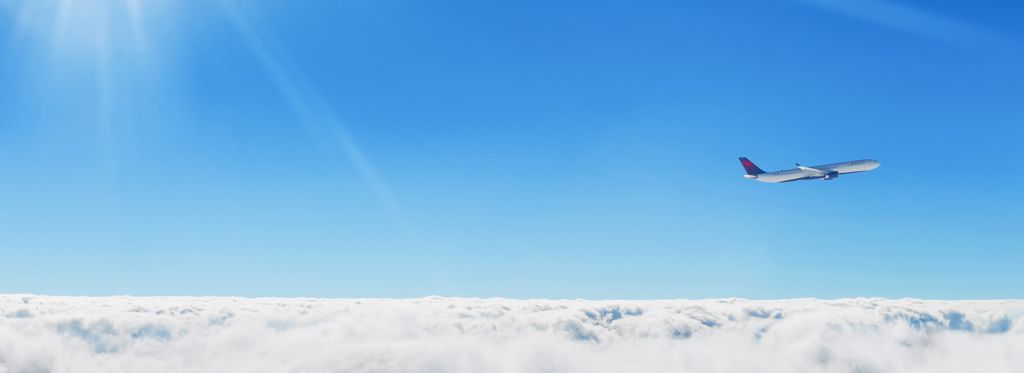 A Delta plane ascends against a blue sky