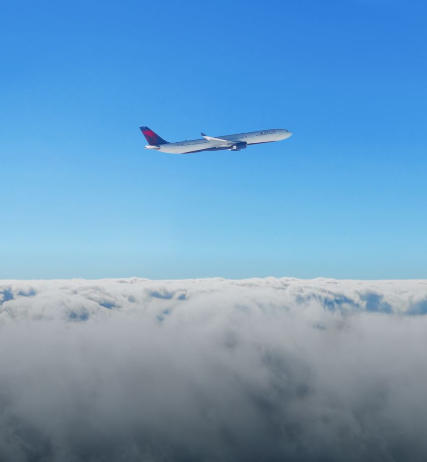 A Delta plane ascends against a blue sky