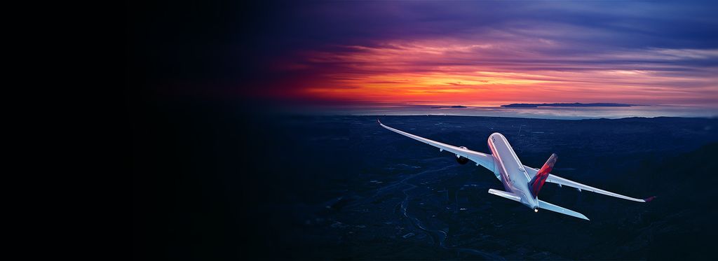 A Delta airplane soars into a colorful sunset, with land and water below, framed by a modern arch design.