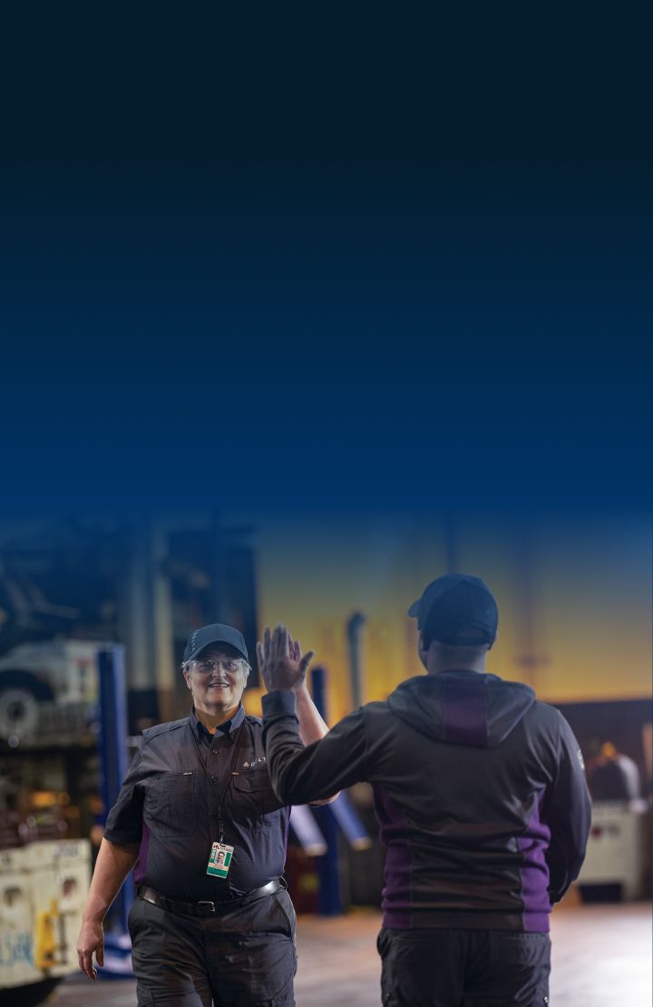 Two Delta employees in uniform giving each other a high-five.